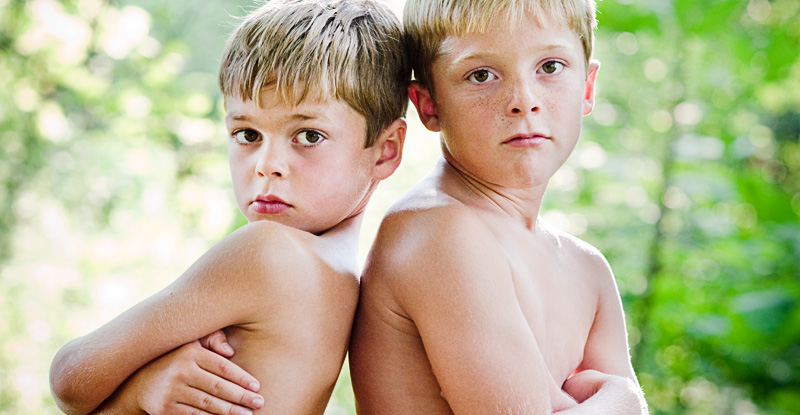 Child portrait: Two brothers doing their best 'tough guy' looks in their special, secret spot in the woods.